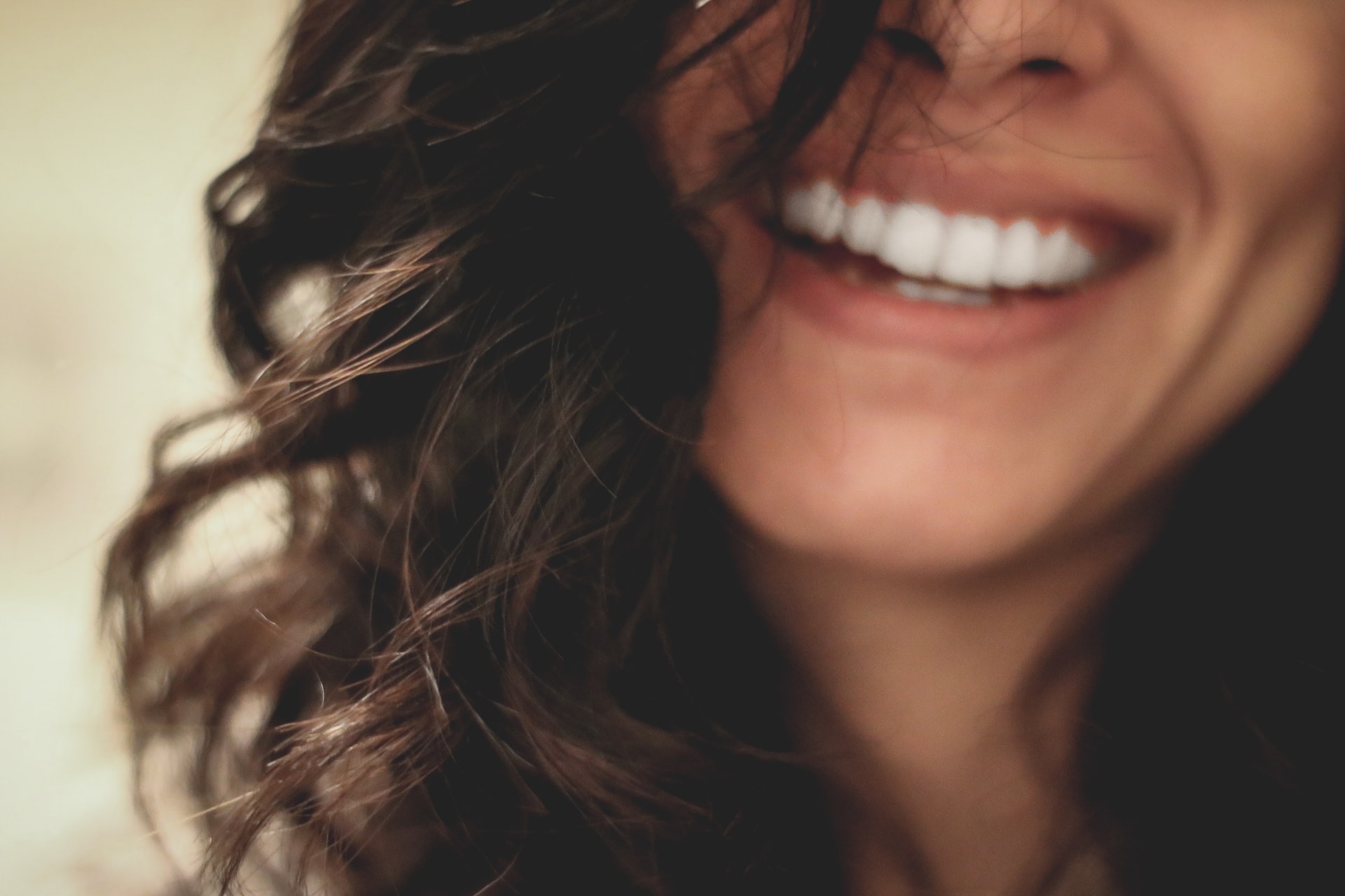A woman smiling revealing white teeth